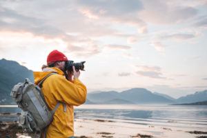 Man taking pictures on professional camera at the beach