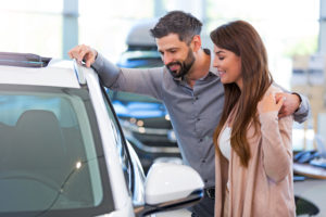 Young couple looking at white car