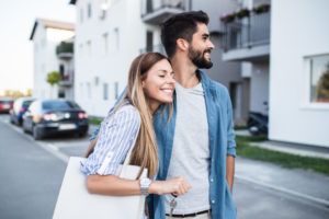 Woman and man standing together smiling holding a key