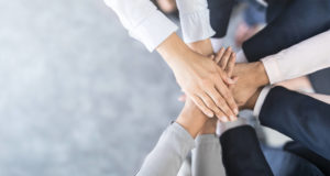 A group of people putting their hands together