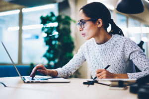 Woman sitting at desk looking at laptop