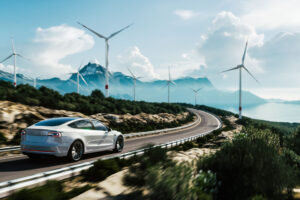 Car driving through windmills with mountainous background